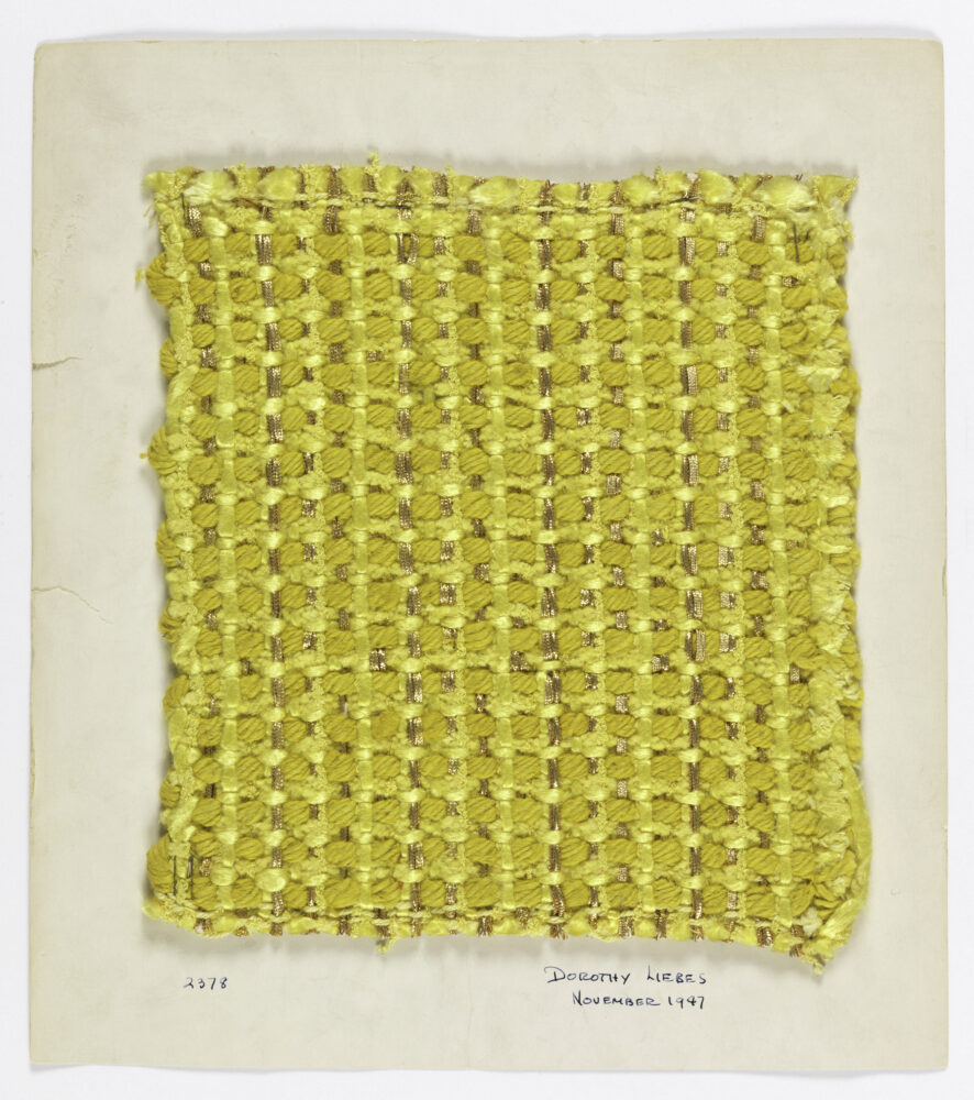 woven textile sample of yellow and gold threads mounted onto a white board