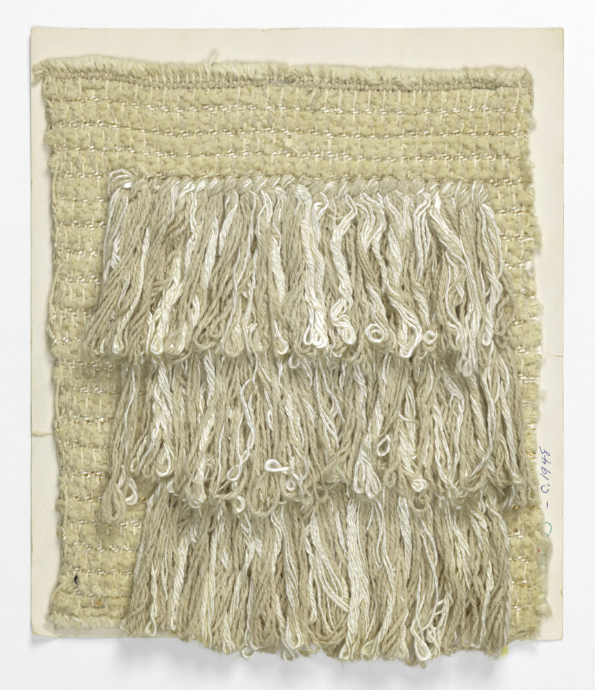 woven textile sample of cream thread with looped fringe details