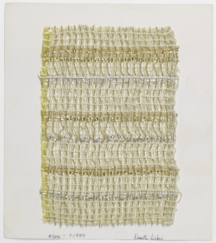 woven textile sample of cream and gold thread mounted on a white board