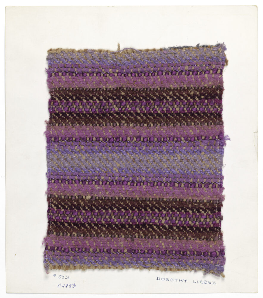 woven textile sample of varying shades of purple threads, mounted onto a white board