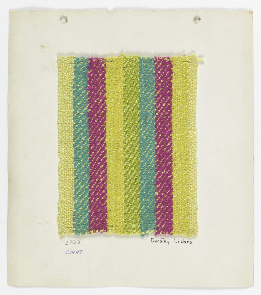 woven textile sample of yellow, aqua, and magenta threads in a vertical stripe pattern, mounted onto a white board