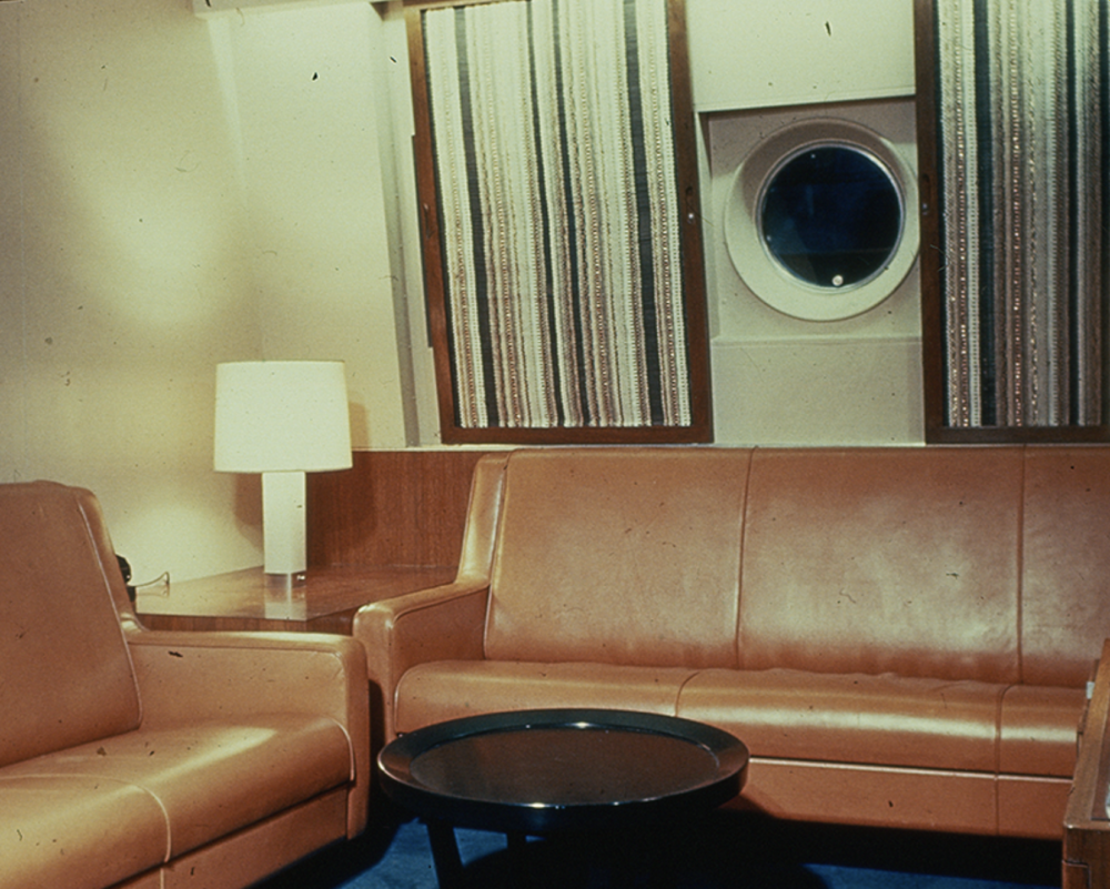 Images of first-class state cabin showing a porthole and striped curtains with metallic accents and furniture in easy-to-maintain and durable fabrics.