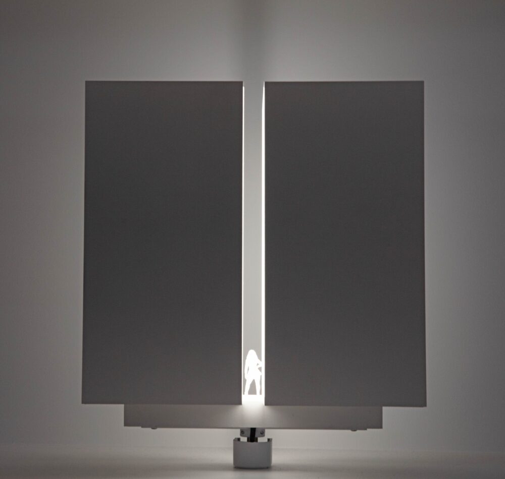 White cubic model that is split in half, vertically, and slightly parted; light glows from within the model revealing a small figure at the base of the opening.