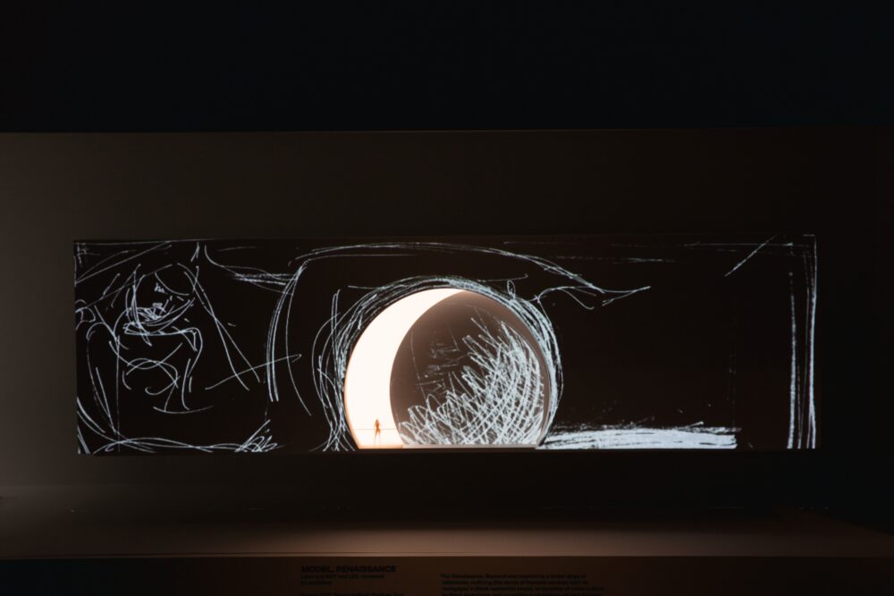 Long horizontal rectangle suspended in a dark space. On the surface is a black background with white lines and marks; a large crescent moon in the center emits light.