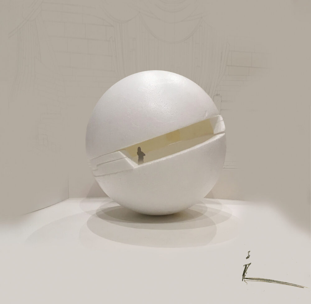 White spherical model with a rectangular cutout along the middle sits on a white surface. A small dark-gray figure stands in the cutout.