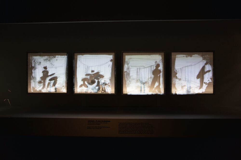 Installation view of a model comprising four cubes lined up next to each other. Drawings are projected onto the four surfaces facing the viewer.