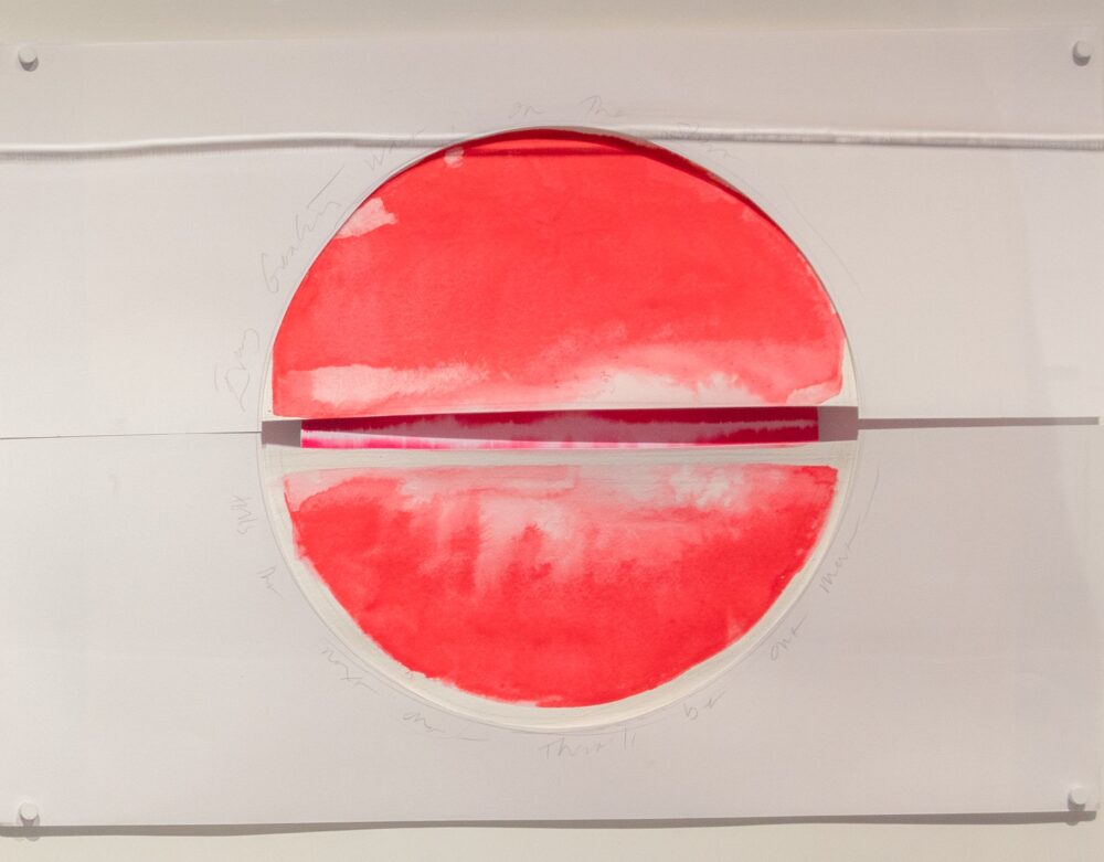 A paper with a textured, red circle in the center that is cut in half, horizontally, and slightly parted revealing another similar paper behind it.
