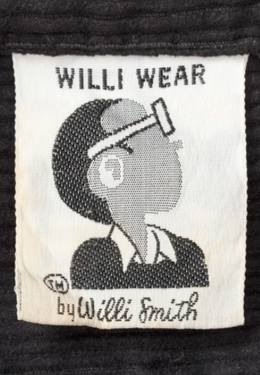 Original WilliWear clothing tag showing a cartoon profile view of Willi Smith with thick glasses, a collared shirt, and sweater