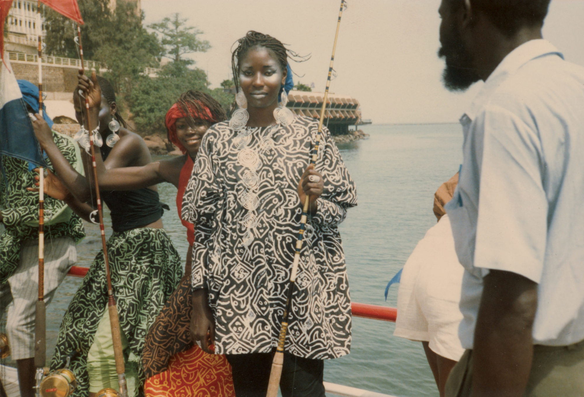 Dancers on a boat wearing vibrant WilliWear garments printed with abstract smiling faces