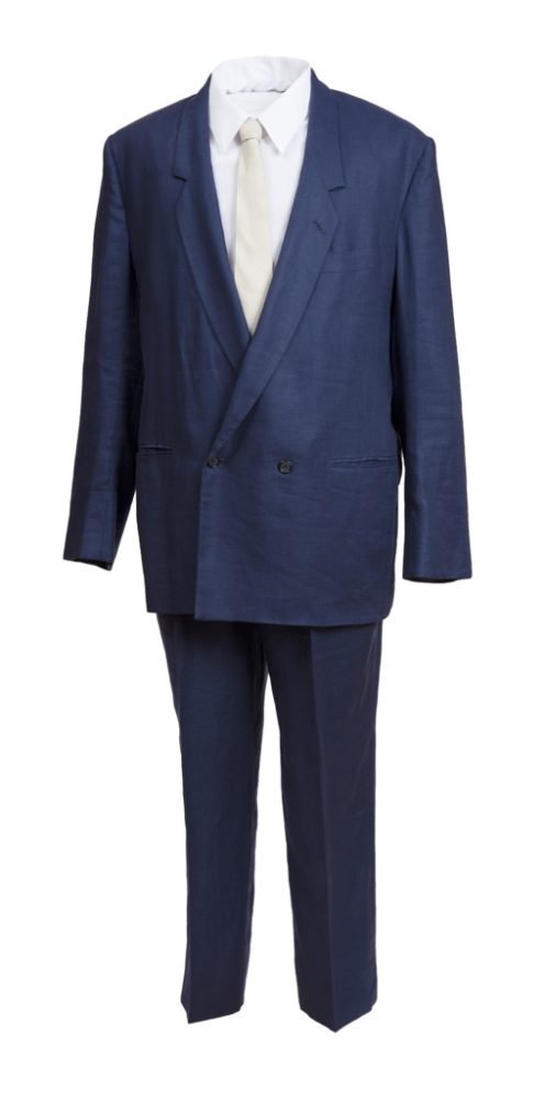 Navy blue men's suit jacket and trousers paired with white dress shirt and pale yellow tie