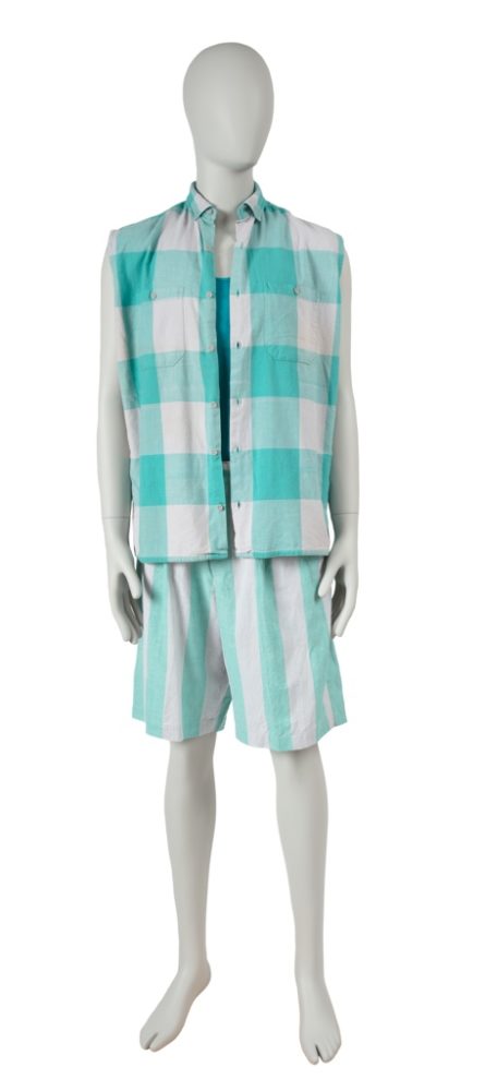 A gray mannequin, facing us, wears a sleeveless aqua and white check shirt with matching striped shorts